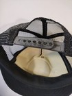 Black trucker hat with gray mesh front, silver snapback closure, and text “MADE IN USA” on the interior panel.