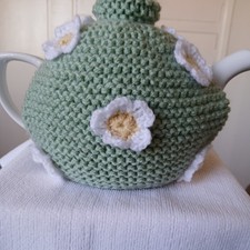 Hand knitted tea cosy medium. pale green decorated with white crochet flowers