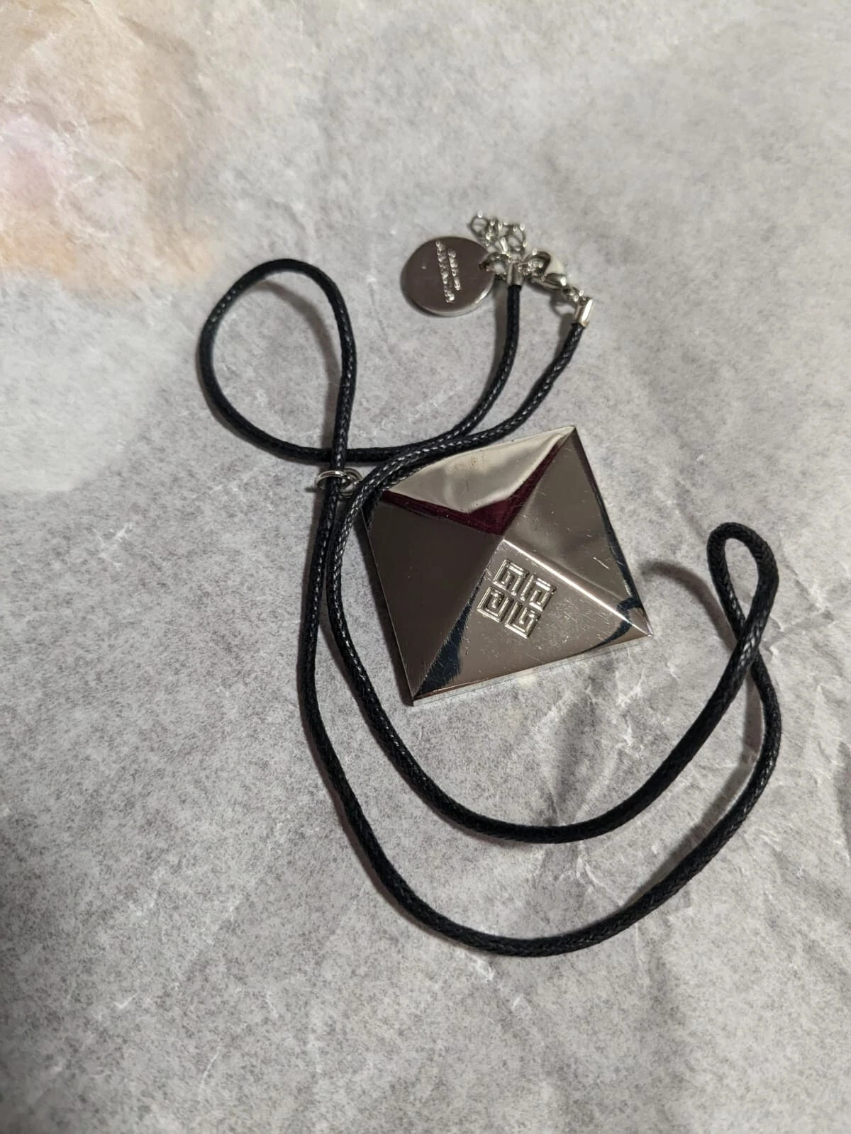 Collana Givenchy. Ciondolo in metallo su catena in pelle regolabile. Condizioni V G