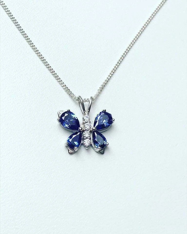 Colgante mariposa de diamantes y tanzanita azul simulado de 1,5 quilates acabado en oro blanco de 14 quilates Foto 4 de 4