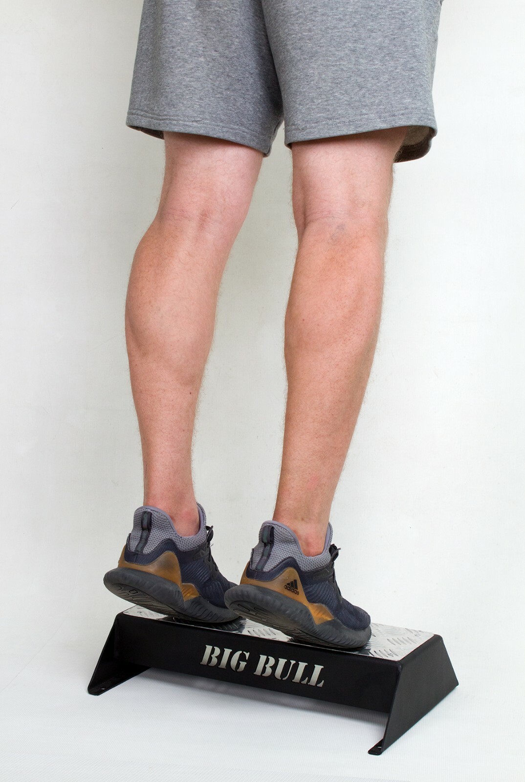 Gimnasio de fitness con bloque de pasos para levantar pantorrillas y entrenamiento muscular