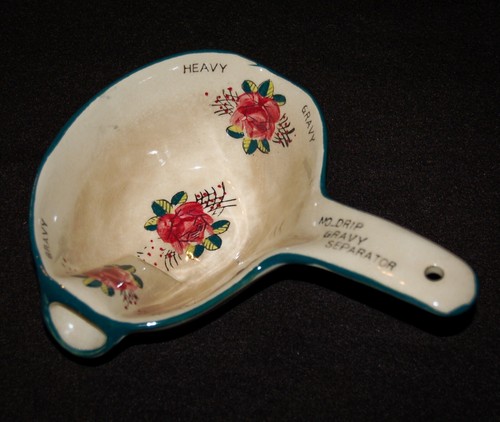 White ceramic gravy separator with red and green floral pattern, teal rim, and text “NO.DRIP GRAVY SEPARATOR” in white.