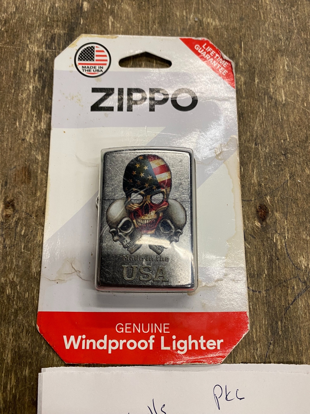 Zippo Lighter 3 skulls Made in U.S.A. box with black/silver design, red/white label, and orange cap.
