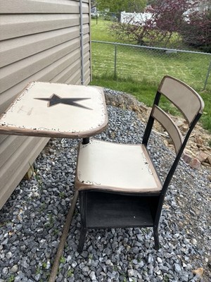 This is a vintage-style metal-framed school desk chair with a painted star mot