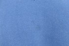 Solid blue VTG 90s Russell Athletic sweatshirt fabric with small white fiber flecks on a textured light gray surface.