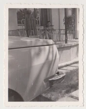 Quiet Reflections: A Young Boy Observes the World from a Porch, Framed by a Car