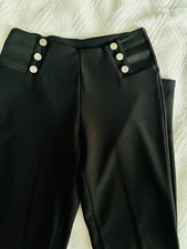 Black high-waisted trousers with silver buttons