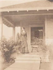 Vera Cecil 1904-18 RPPC woman in dress standing on porch looking at flowers AZO