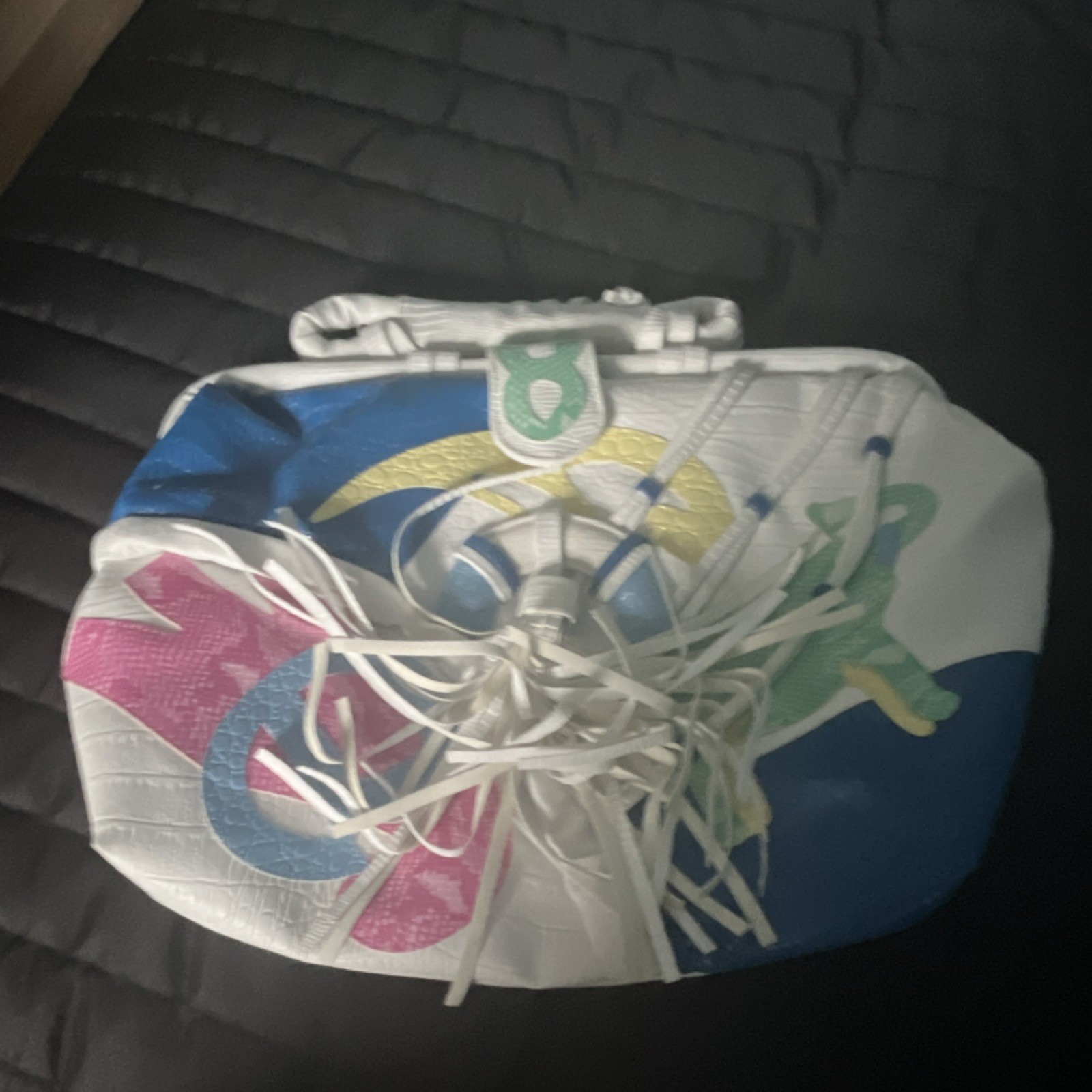 Bandolera blanca con flecos en relieve con estampado de animales, asa superior, cremallera y broche de presión
