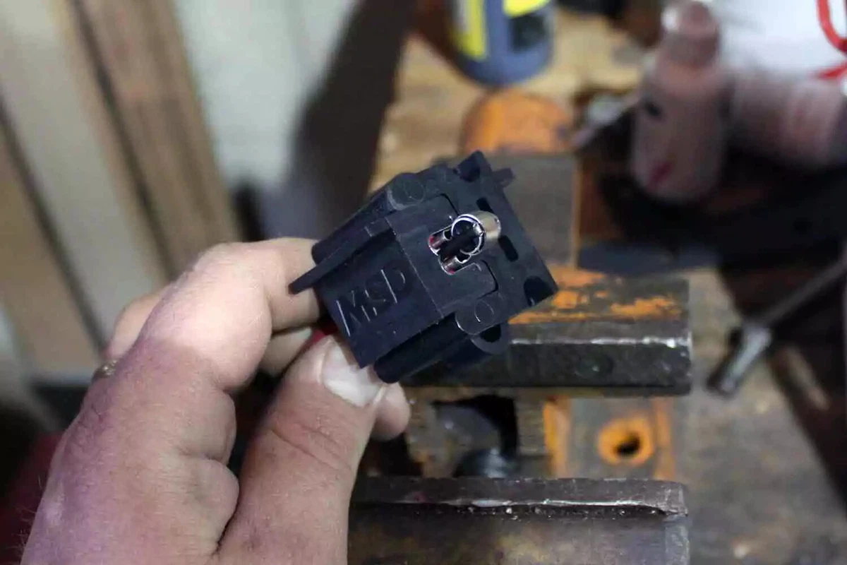 A mechanic holds an MSD wire crimper while assembling a custom-fit spark plug wire.