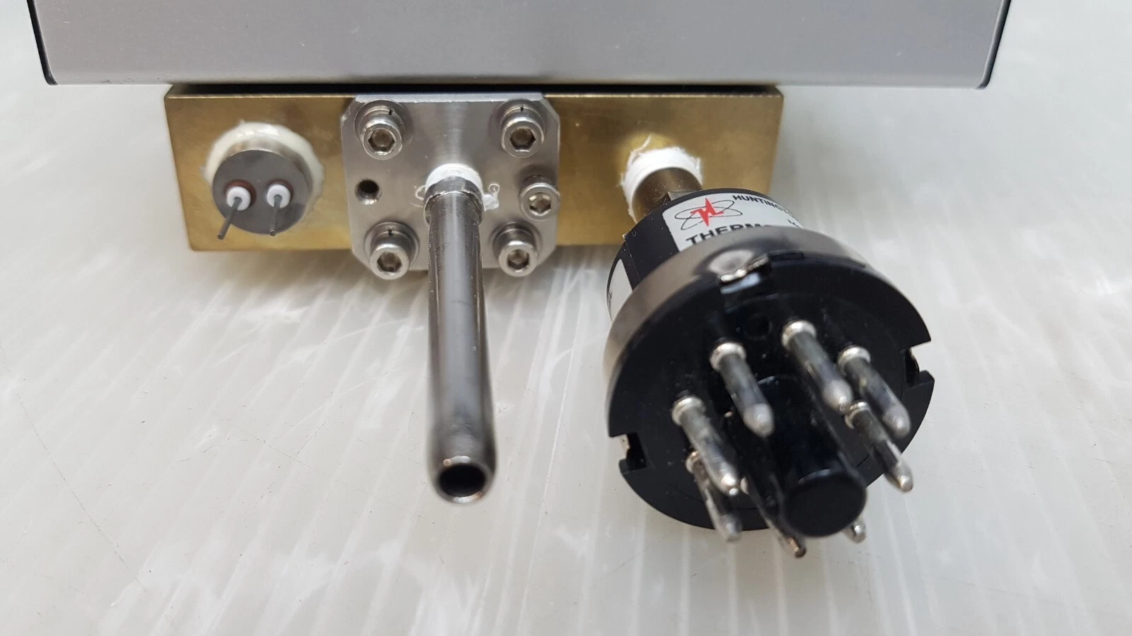 Brass block ports: 2-pin feedthrough, steel tube on flange and gauge tube base