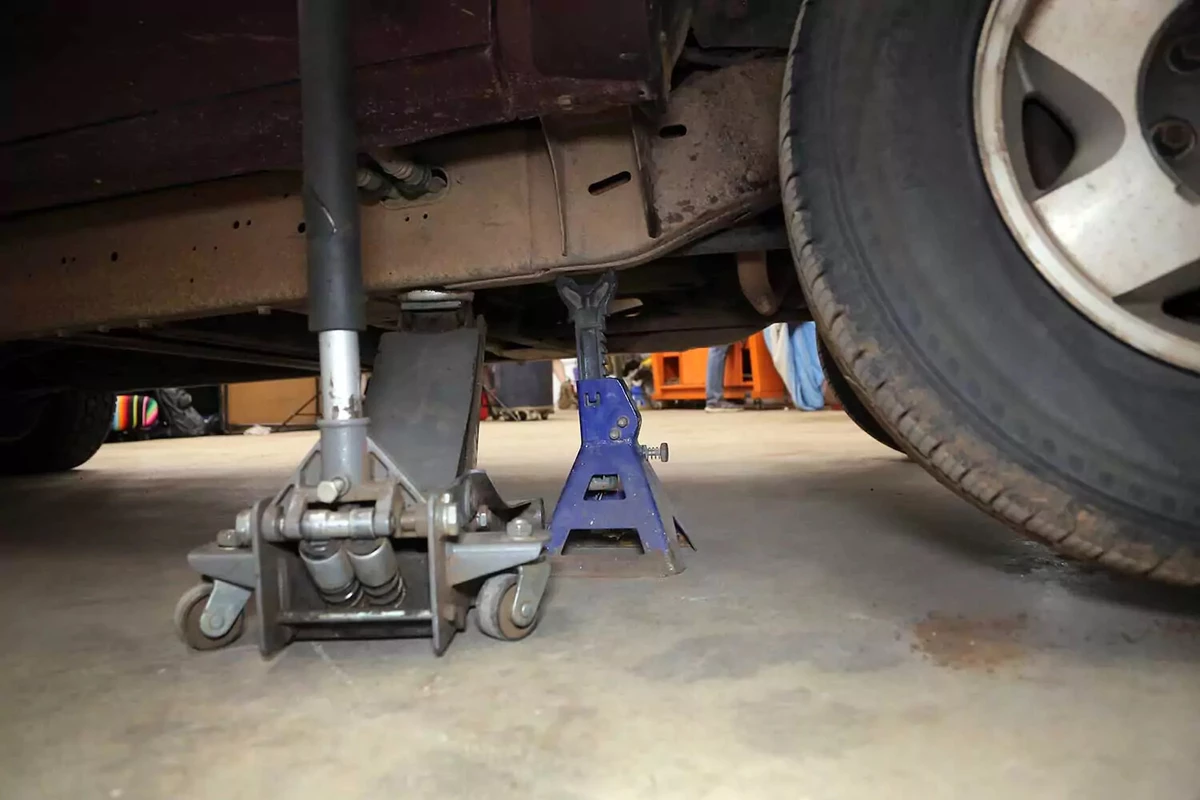 A truck lifted with a floor jack and jack stand.