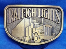 Vintage Raleigh Lights Belt Buckle Semi Truck Trucker Metal Brass Colored. NOS