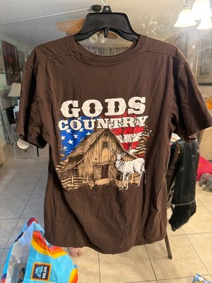 brown graphic t-shirt with the text ''Gods Country'' above an illustration of a ba