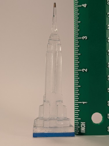 Clear vintage Lucite Empire State Building miniature with blue base, shown beside green ruler measuring approximately 3 inches tall.