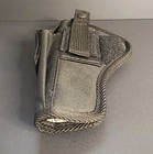 Black nylon, USA made, ambidextrous IWB holster with flap pocket and silver snap closure on a gray surface.