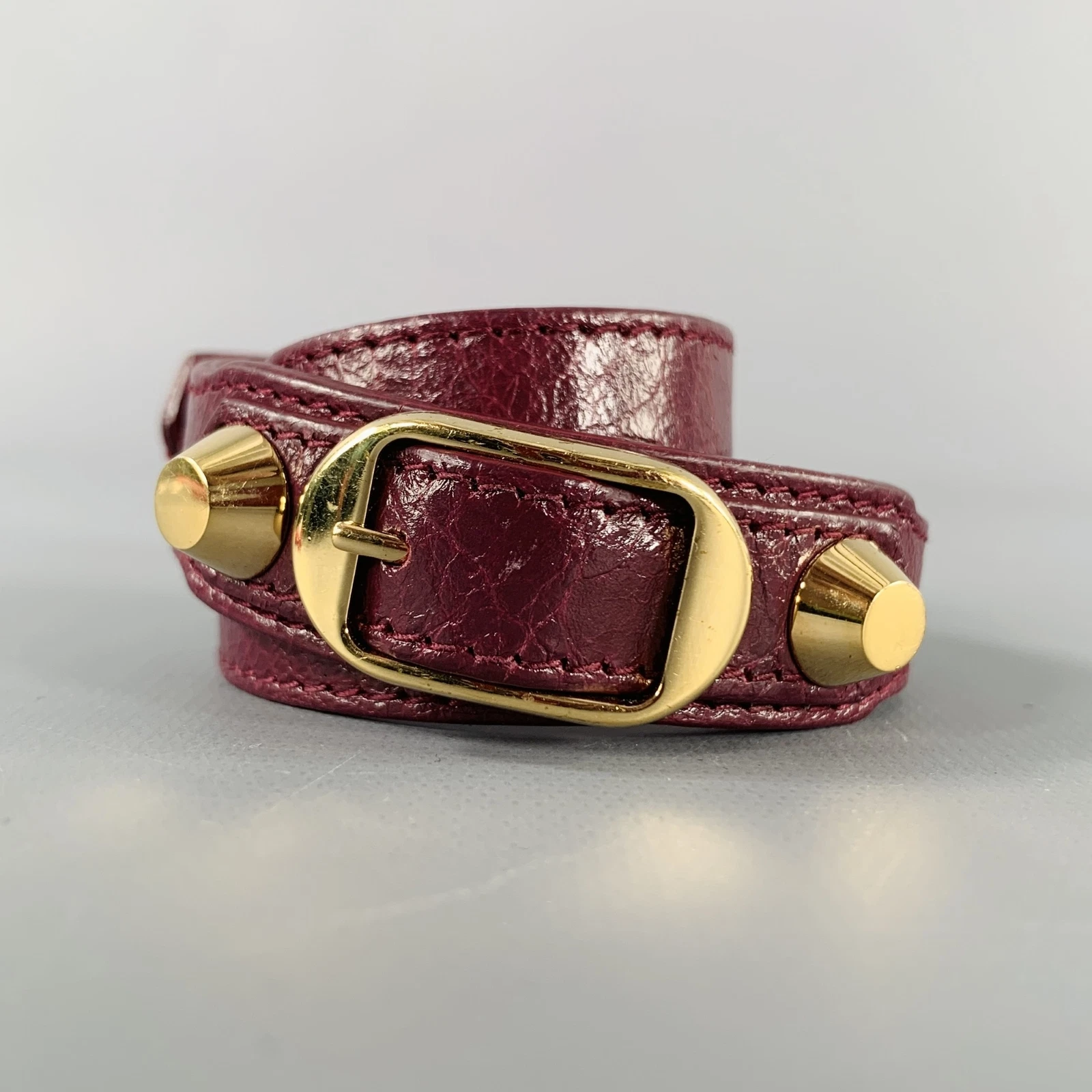Bracciale BALENCIAGA in pelle borchiata oro bordeaux