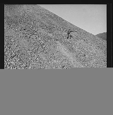 Kingman (vicinity), Arizona. A huge waste pile, showing a workman near the