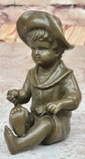 Vintage cast stone statue of a young boy Holding a Ball in His Hand Statue