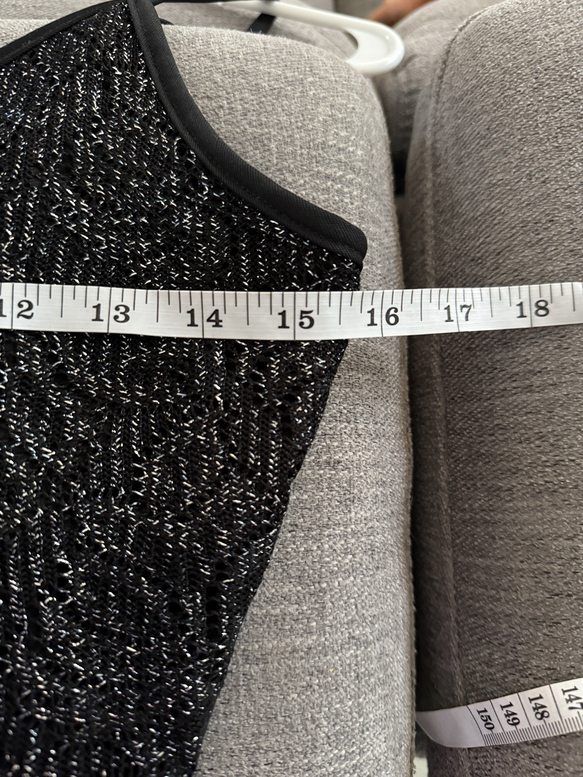 Black Y2K tank crop top with silver fringe trim, displayed on hanger against light gray fabric background.