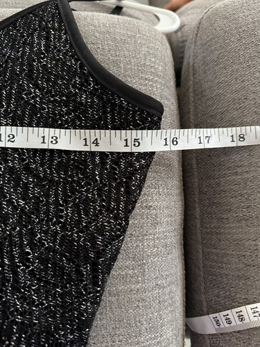 Black Y2K tank crop top with silver fringe trim, displayed on hanger against light gray fabric background.