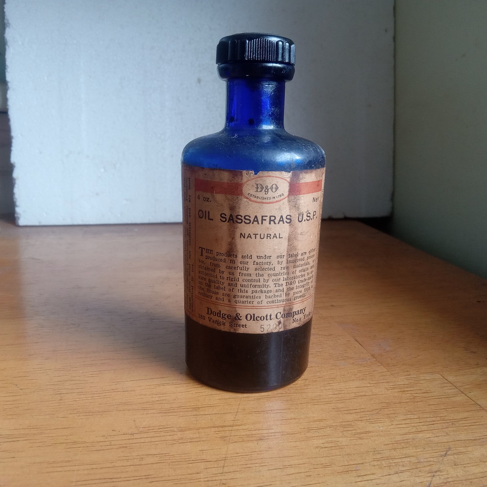 1918 DODGE & OLCOTT OIL SASSAFRAS COBALT LABELED BOTTLE W/STOPPER & CONTENTS