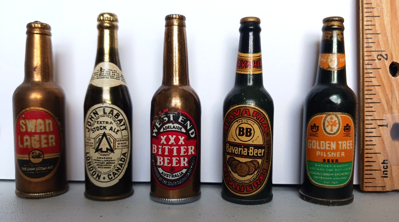 4 vintage bottle-shaped beer advertising lighters and 1 dice game in a bottle