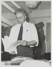 Photo:Roy Emerson Stryker Portrait Looking Through Photographs 1930s