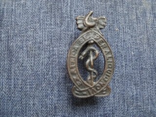 #005 EAST AFRICAN MEDICAL CORPS BLACKENED METAL CAP BADGE