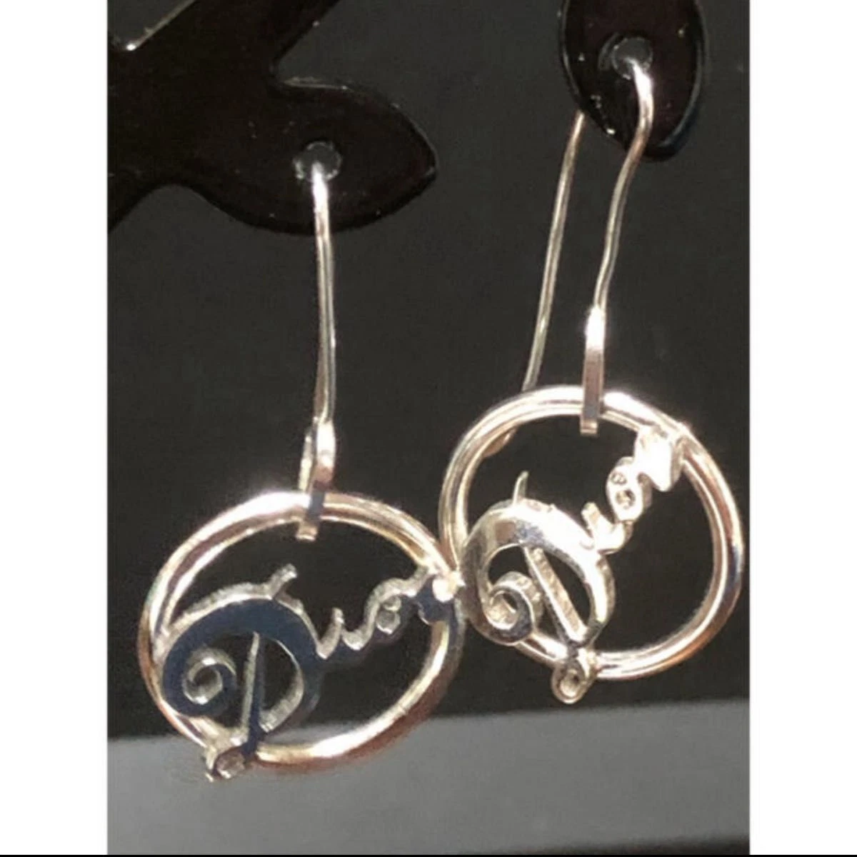 Boucles d'oreilles crochet logo cercle Christian Dior ton argent accessoire bijoux femme