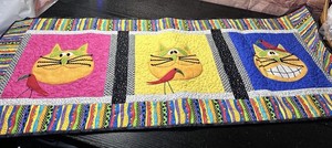 Quilted Multi-color table runner features vibrant feline appliqué work