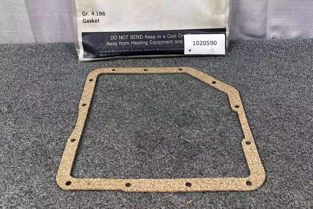 A new transmission oil pan gasket sitting on a gray surface.
