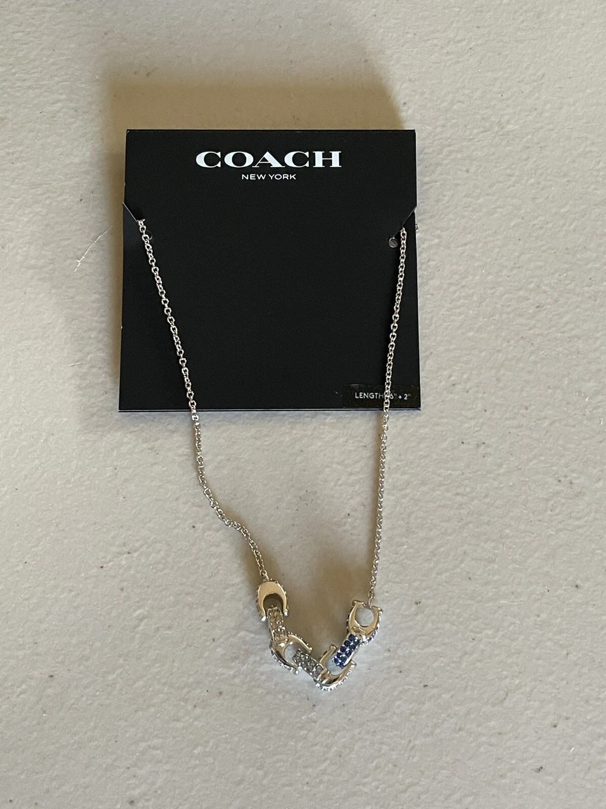 COLLANA CIONDOLO COACH SIGNATURE “C” TONO ARGENTO CRISTALLI CHIARI E BLU 16”+2”