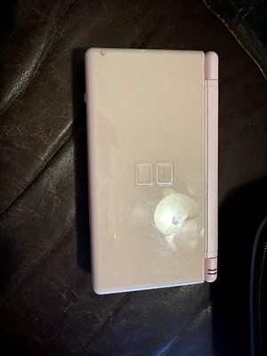 nintendo ds lite pink with wall charger, games, and carrying case