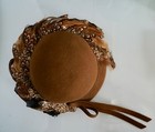 Brown hat with 100% wool EXCELLO, pheasant feathers, and tan ribbon on white background.