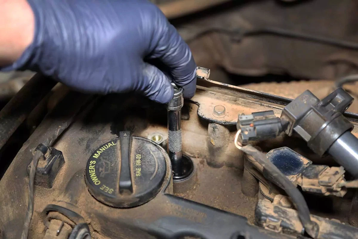 Socket and extension being used to hand-tighten the new spark plug.