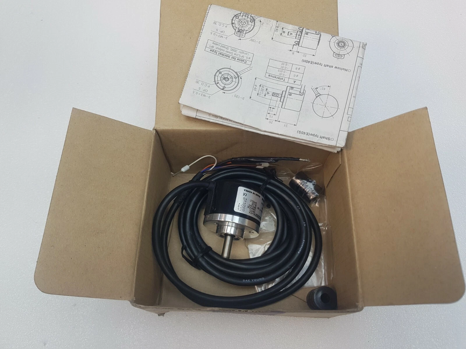 Autonics E40S6 encoder with coiled cable in its open box with instruction sheet