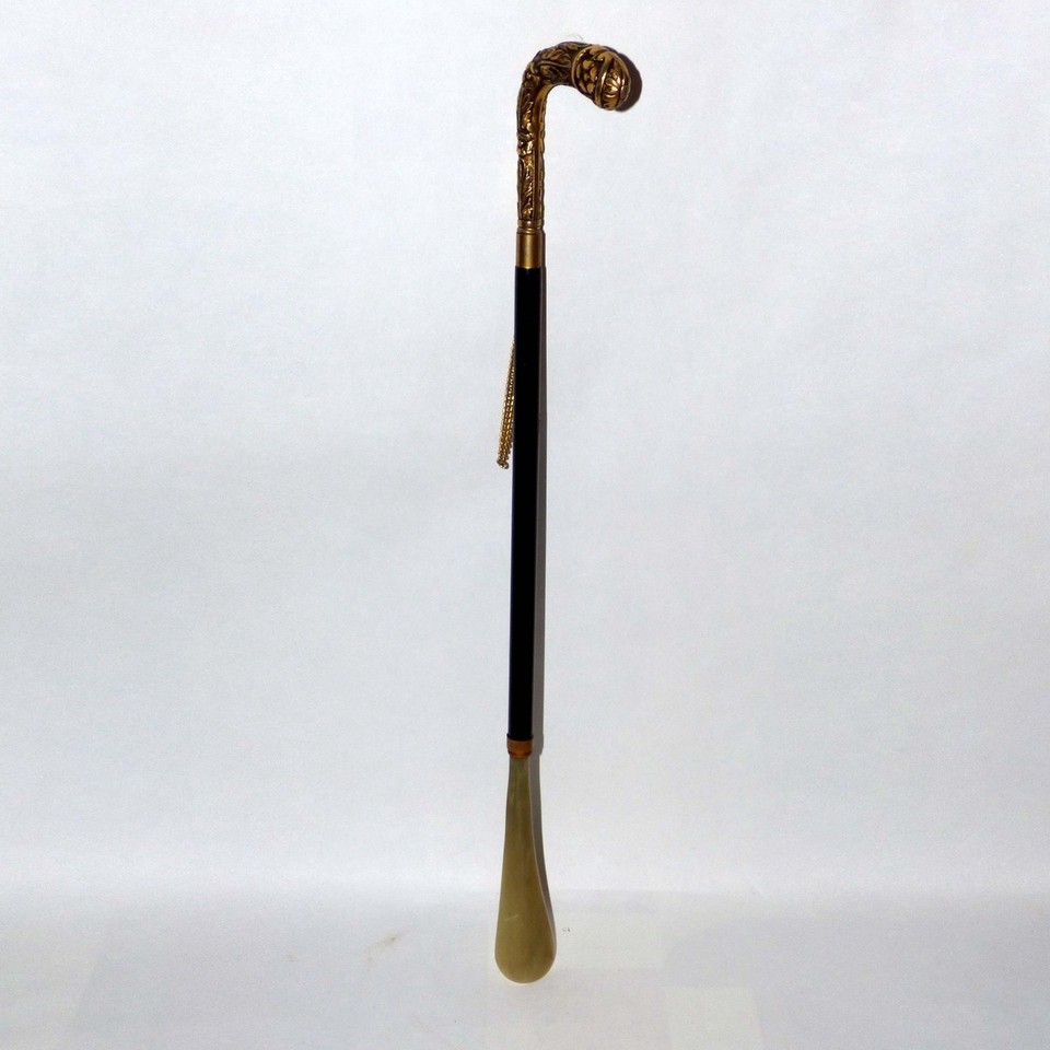 An ornate long-handled brass shoehorn that feels like it belongs in a Victorian gentleman's dressing room — absurdly distinguished and genuinely useful.