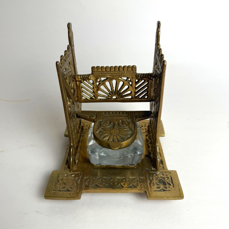 An ornate antique brass inkwell set with a real glass insert — the kind of desk centerpiece that signals you take your correspondence very seriously.