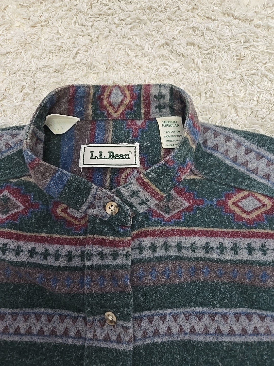 Vintage LL Bean men’s L gray green flannel with red, blue, and beige Aztec-style stripes and white LL Bean logo on collar.