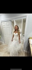Elegant Strapless Sweetheart Wedding Dress with Ruffled Skirt and Veil.