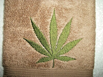 MARIJUANA LEAF DESIGN EMBROIDERED ONTO A DARK BROWN COLOR HAND TOWEL