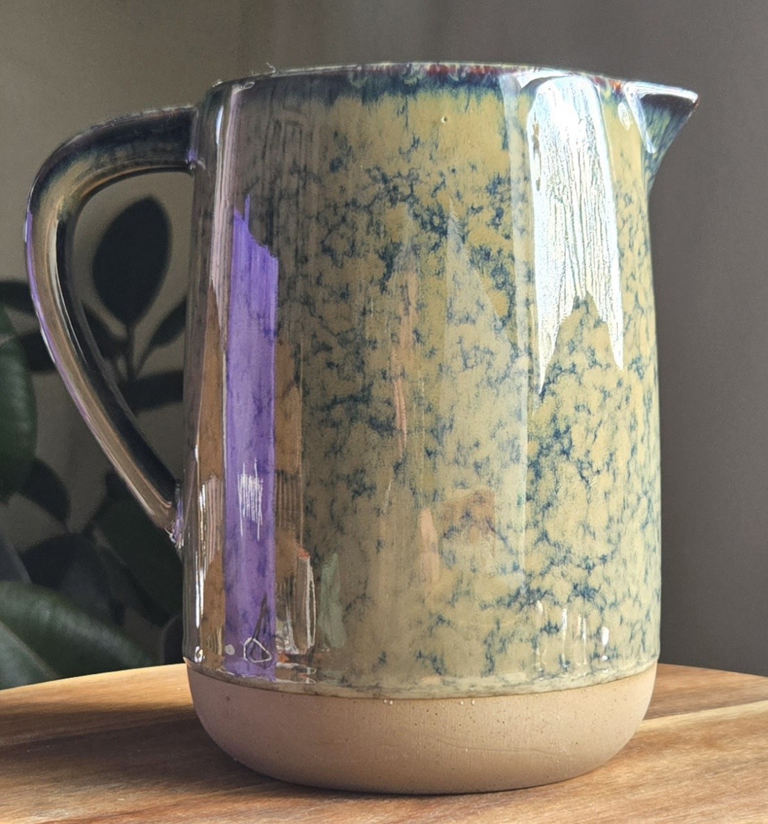 Blue and beige spongeware pitcher on a plain background.