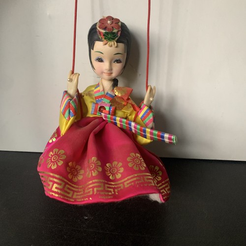 Vintage schöne koreanische indianische Puppe sitzend auf Schaukel hat Steine zum Aufhängen
