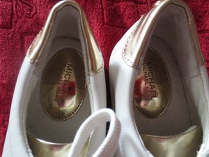 white sneakers with gold accents