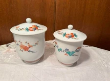 Pair of teacups with lids, featuring a blue and white design of brocade plum blo