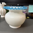 Fenton Art Glass Aqua Crest milk glass vase with a ruffled blue rim.