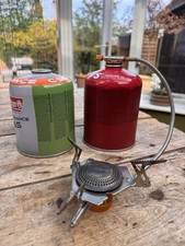 Compact backpacking/camping gas stove setup with two different fuel canisters.