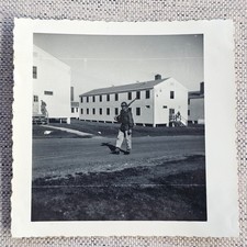 ORIGINAL WWII ERA PHOTOGRAPH ARMY SOLDIER CARRYING RIFLE NEAR BARRACKS BUILDINGS