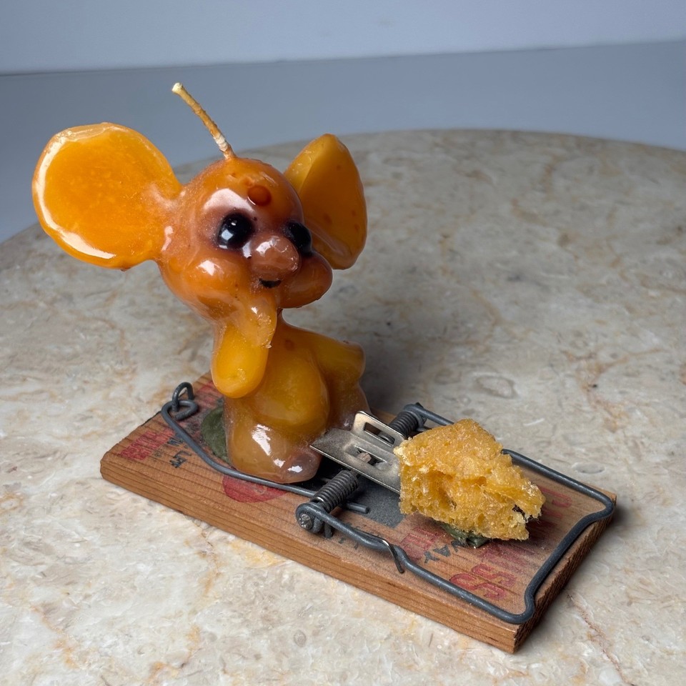 A tiny wax mouse caught in a mousetrap candle is peak kitsch — the kind of thing that makes guests do a double-take on your shelf.